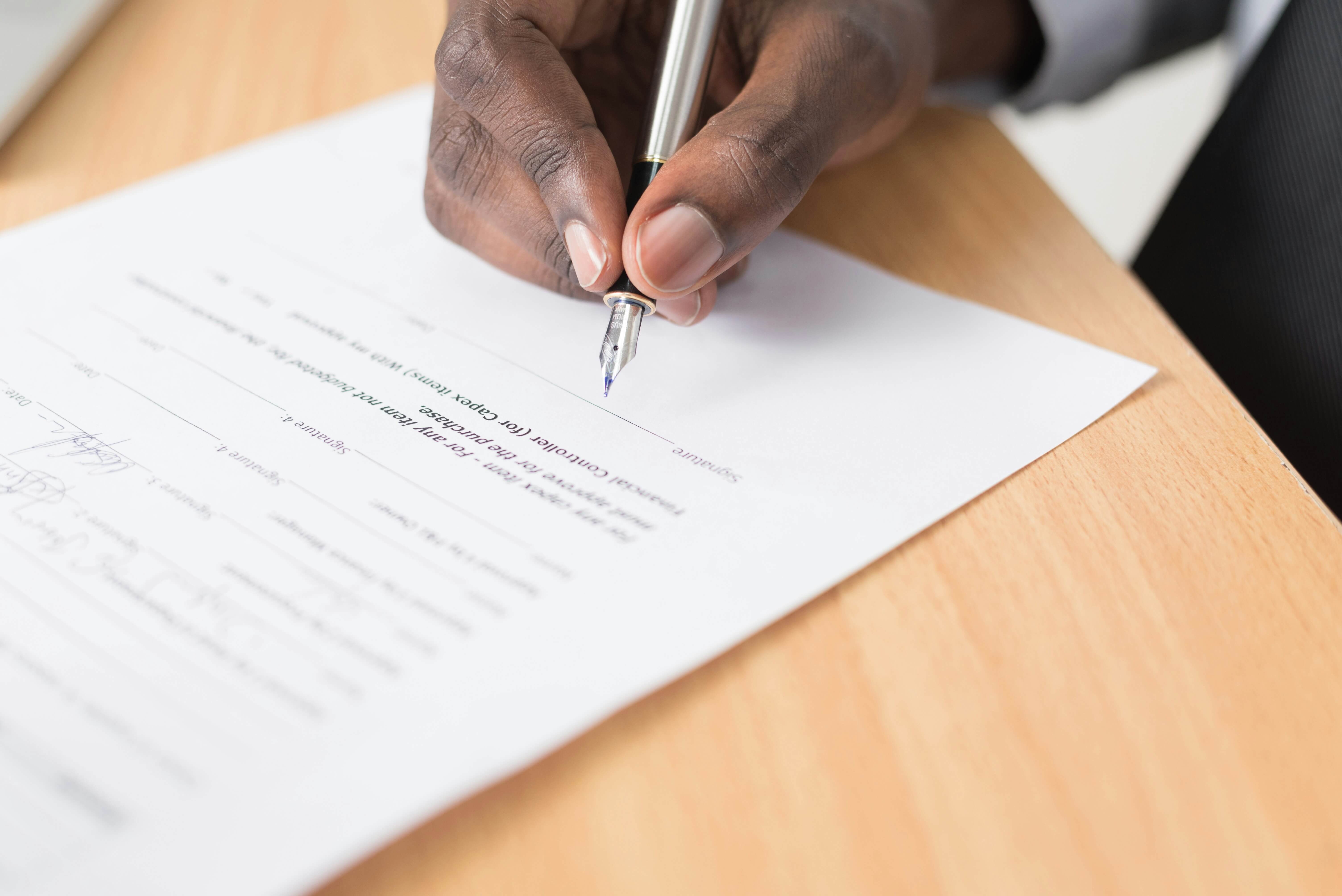 A hand signing a contract 